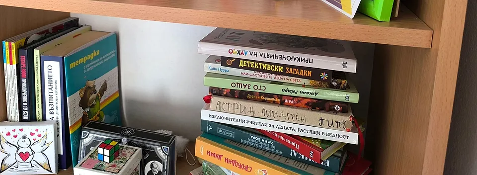 Рафт с детски книги, подредени за четене, и картичка на Светлинки